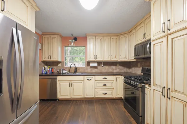 a kitchen with stainless steel appliances a refrigerator sink and cabinets