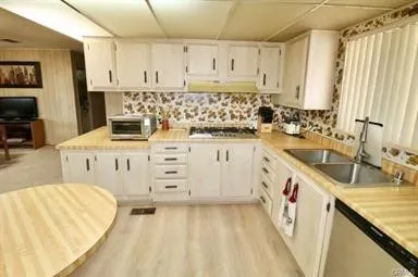 a kitchen with granite countertop a sink a stove and cabinets