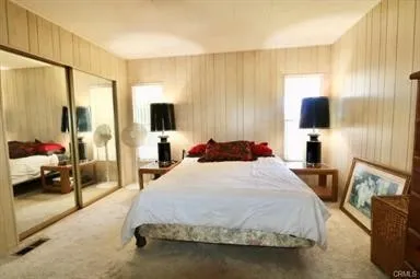 a bedroom with a bed flat screen tv and a couch