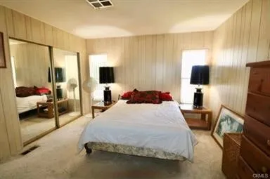 a bedroom with a bed and flat screen tv