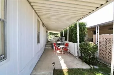 a view of a patio with table and chairs potted plants with floor to ceiling window