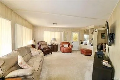 a living room with furniture a flat screen tv and a window