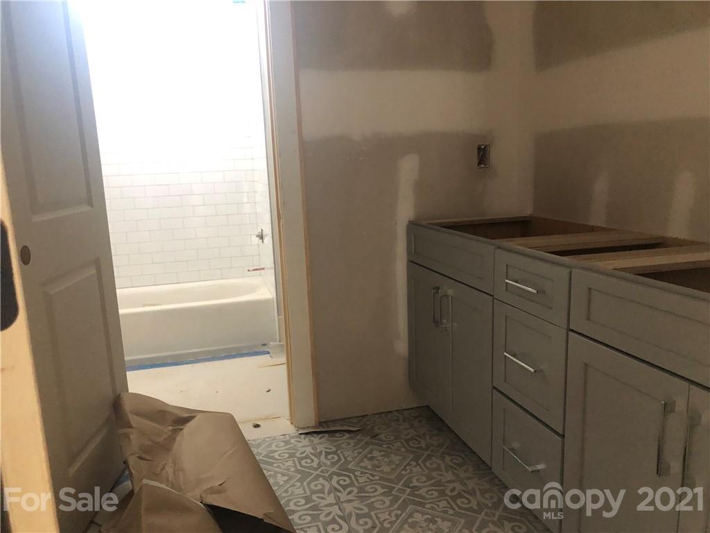 5520 Closeburn Road Charlotte, NC 28210 - Photo 24 of 32 a bathroom with a granite countertop sink and a bathtub