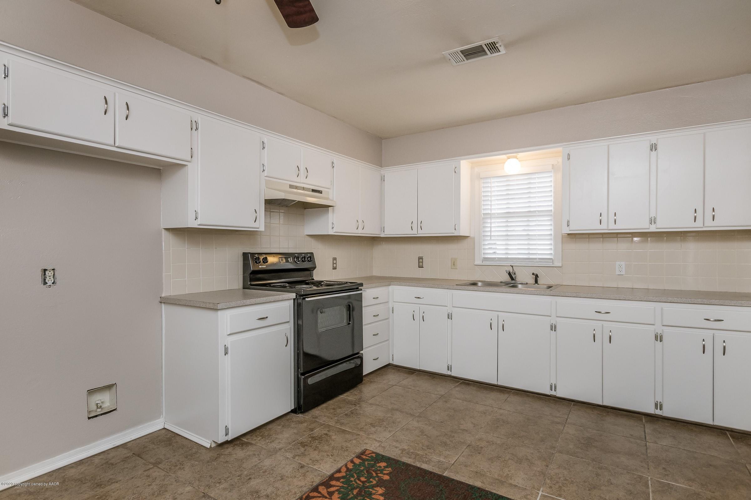 4301 South Jackson Street Amarillo, TX 79110 - Photo 4 of 18 a kitchen with granite countertop white cabinets sink and stainless steel appliances