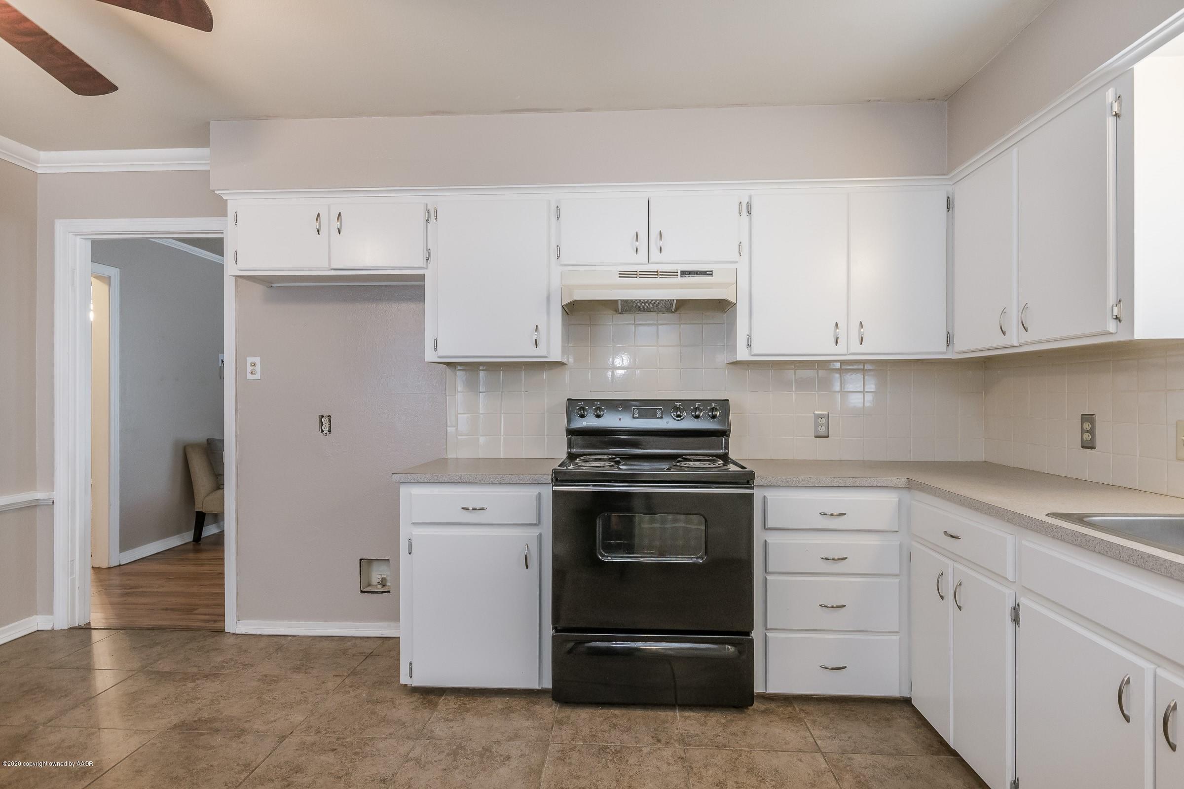 4301 South Jackson Street Amarillo, TX 79110 - Photo 5 of 18 a kitchen with granite countertop white cabinets and stainless steel appliances