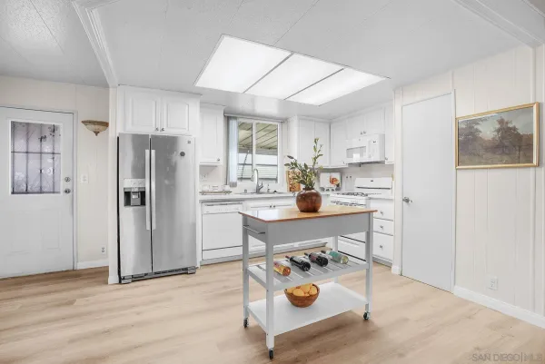 a kitchen with a refrigerator and a stove top oven