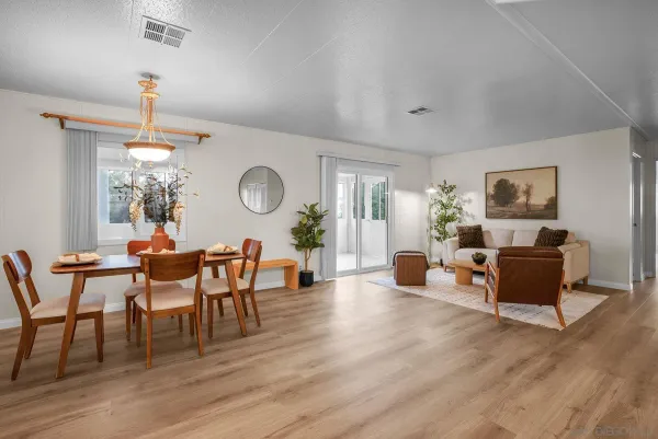 a dining room with wooden floor a chandelier a wooden table and chairs