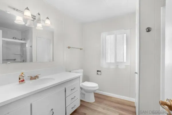 a bathroom with a sink a toilet and a large mirror