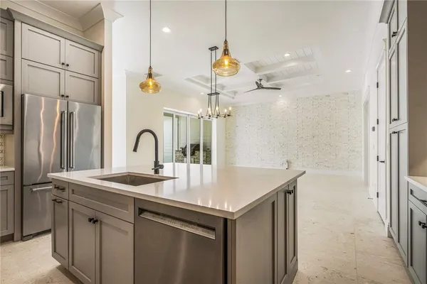 a kitchen with a sink a counter space and a refrigerator