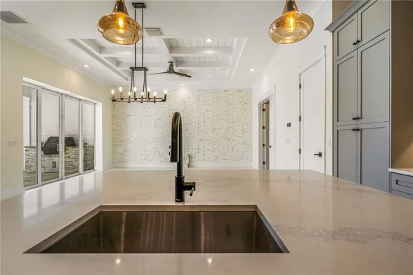 a kitchen with a sink a counter space and a chandelier