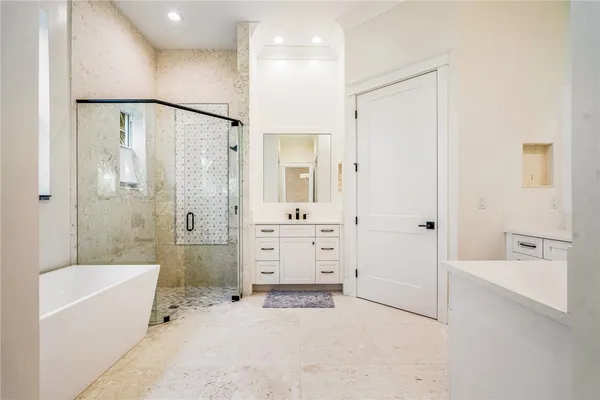 a bathroom with a tub a sink and shower