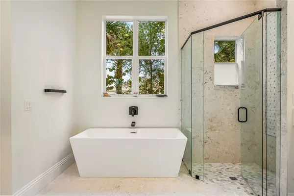 a white bath tub sitting next to a shower