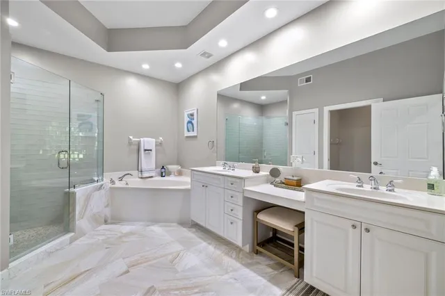 a bathroom with a sink double vanity granite tub shower and a mirror