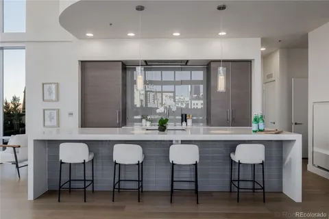 a kitchen with kitchen island granite countertop a sink and refrigerator