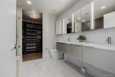 a bathroom with a double vanity sink a mirror and a shower