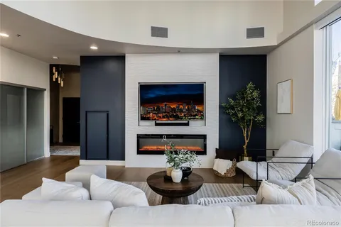 a living room with furniture a fireplace and a potted plant