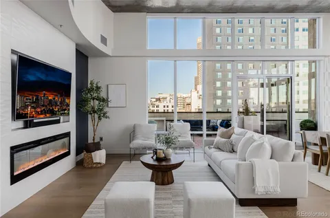 a living room with furniture a fireplace and a large window