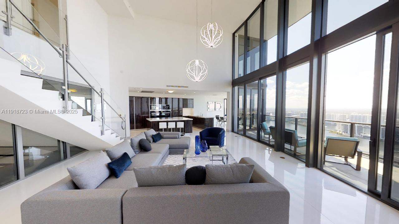 18555 Collins Avenue, Unit 4804 Sunny Isles Beach, FL 33160 - Photo 24 of 51 a living room with furniture and a large window