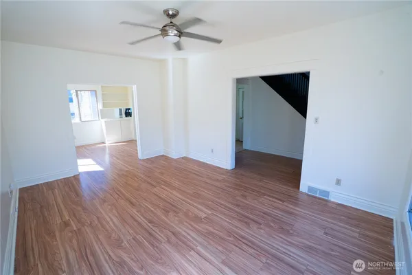 a view of empty room with wooden floor