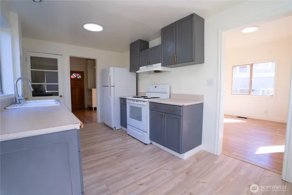 a kitchen with stainless steel appliances granite countertop a sink stove and wooden floor