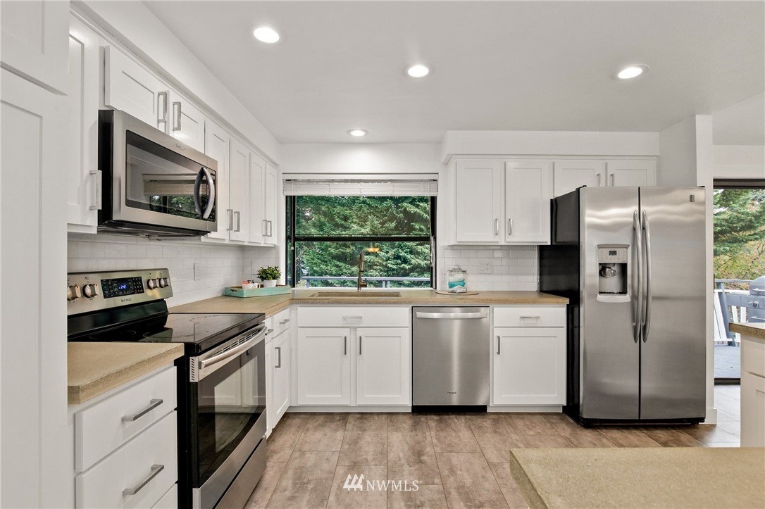 15504 Southeast 178th Place Renton, WA 98058 - Photo 11 of 40 a kitchen with a refrigerator stove microwave and sink