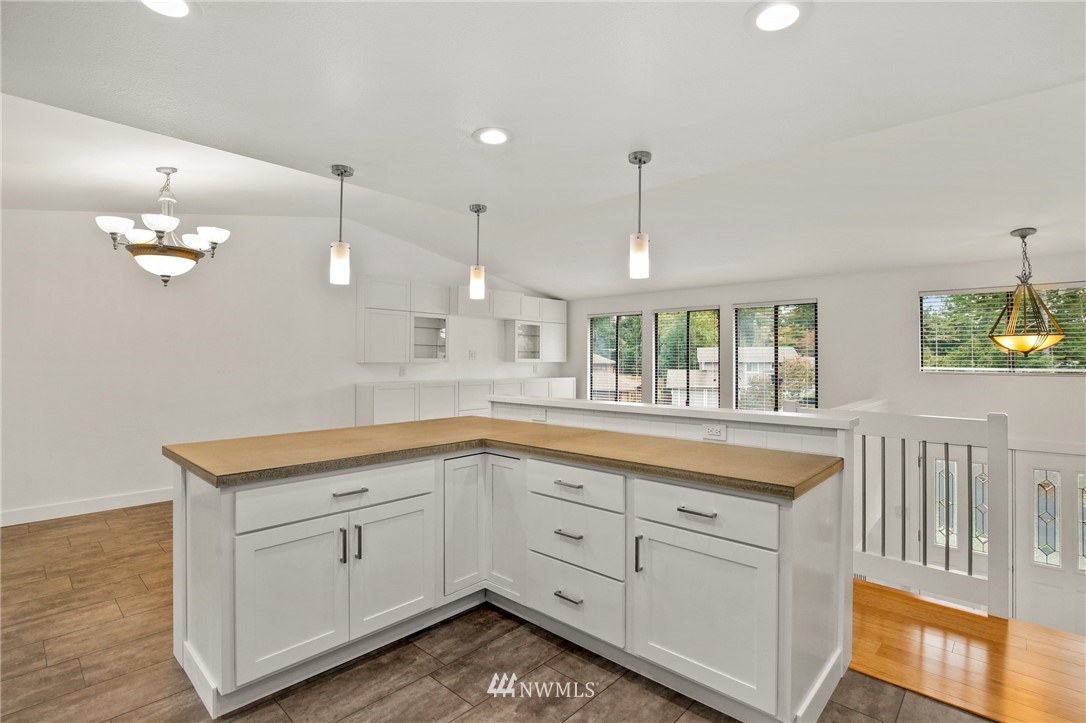 15504 Southeast 178th Place Renton, WA 98058 - Photo 13 of 40 a kitchen with a sink dishwasher and white cabinets with wooden floor