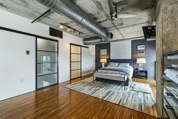 a hallway with a bed and a wooden floor