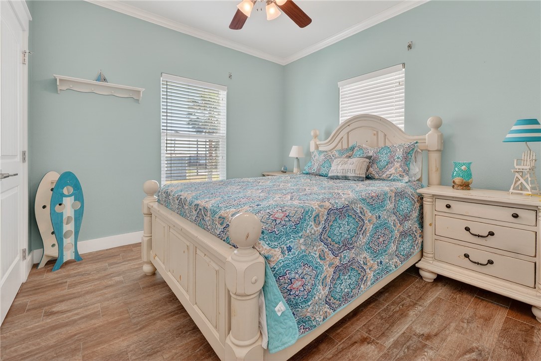 838 Rattlesnake Point Road Rockport, TX 78382 - Photo 21 of 40 a bedroom with a bed and a chandelier