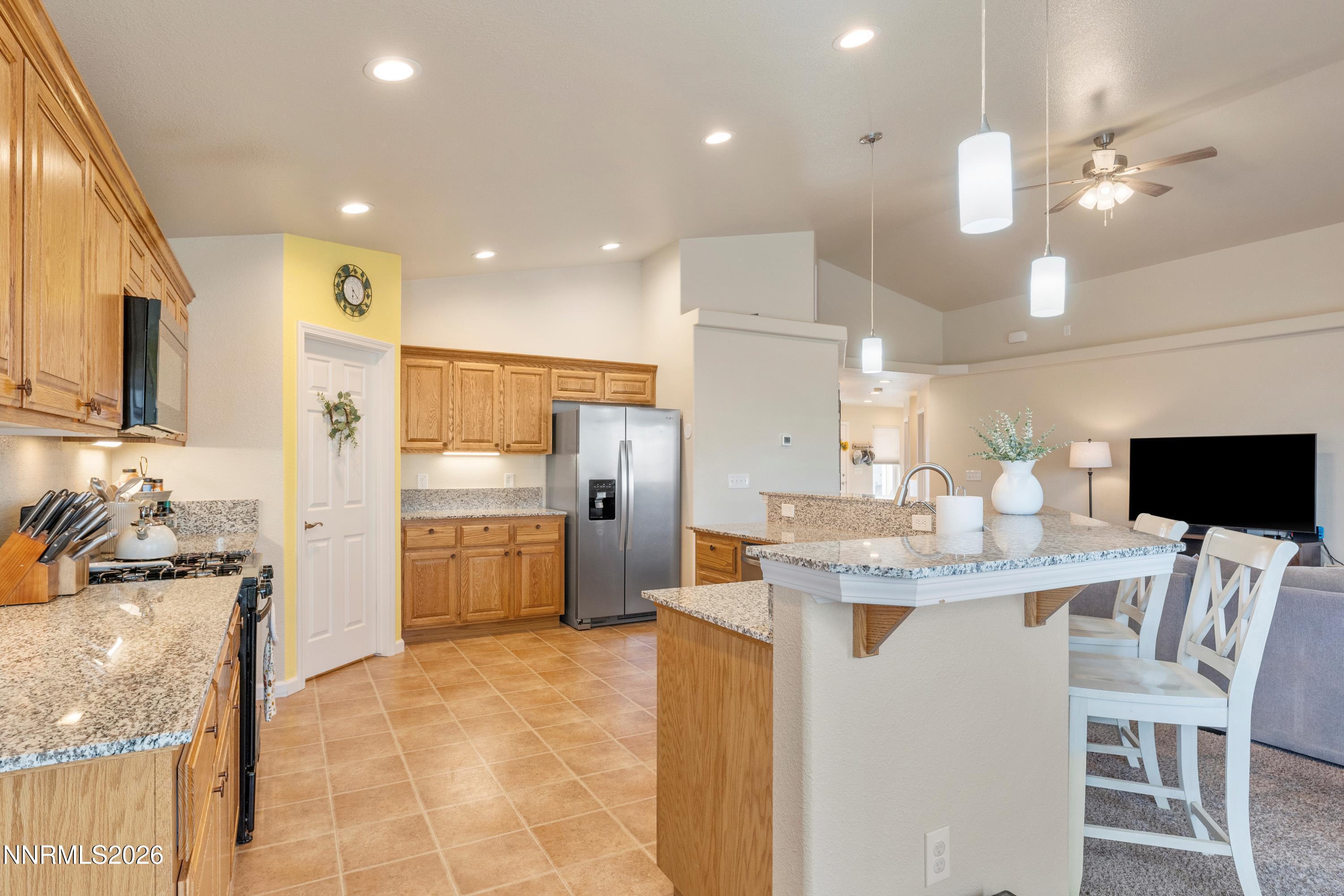 4540 Rutledge Street Fernley, NV 89408 - Photo 6 of 16 a kitchen with kitchen island granite countertop a sink and refrigerator