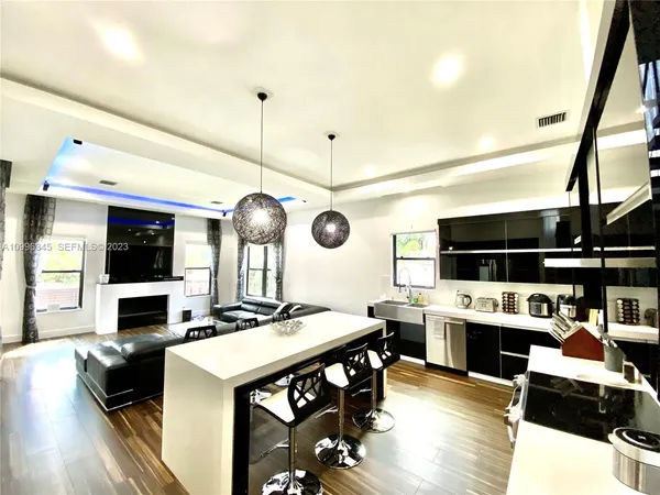 a living room with furniture a flat screen tv and kitchen view