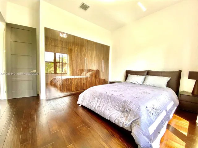 a bedroom with a bed and wooden floor
