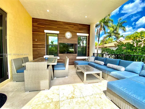 a living room with patio furniture and a large window