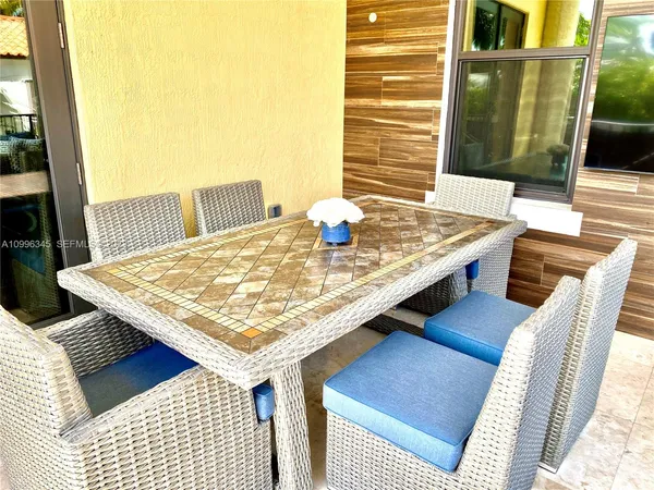 a view of a balcony with table and chairs and wooden fence