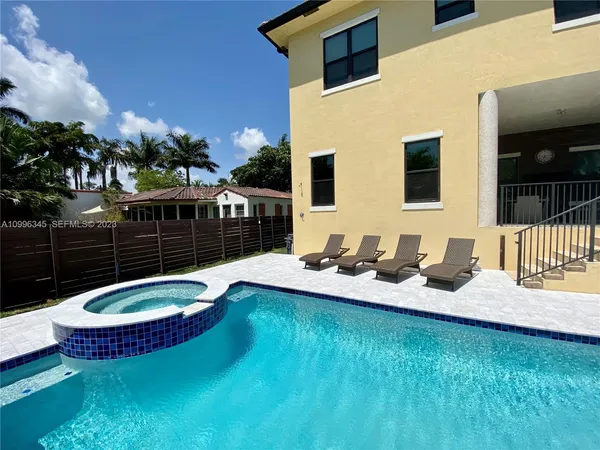 a view of a house with backyard swimming pool and sitting area