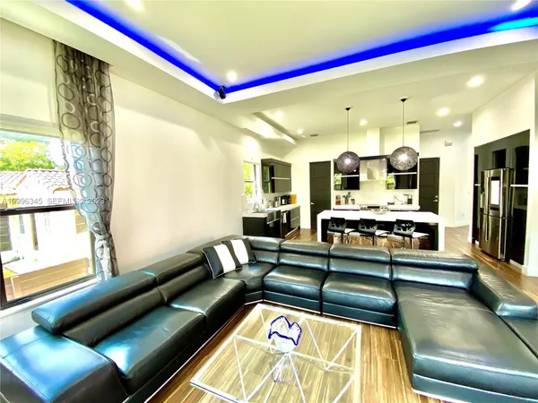 a living room with stainless steel appliances furniture and a large window