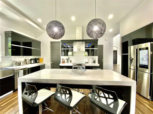 a kitchen with stainless steel appliances a dining table and chairs