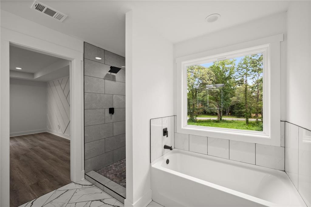 182 Hardman Road Clarkesville, GA 30523 - Photo 46 of 62 a bathroom with a bathtub shower and window