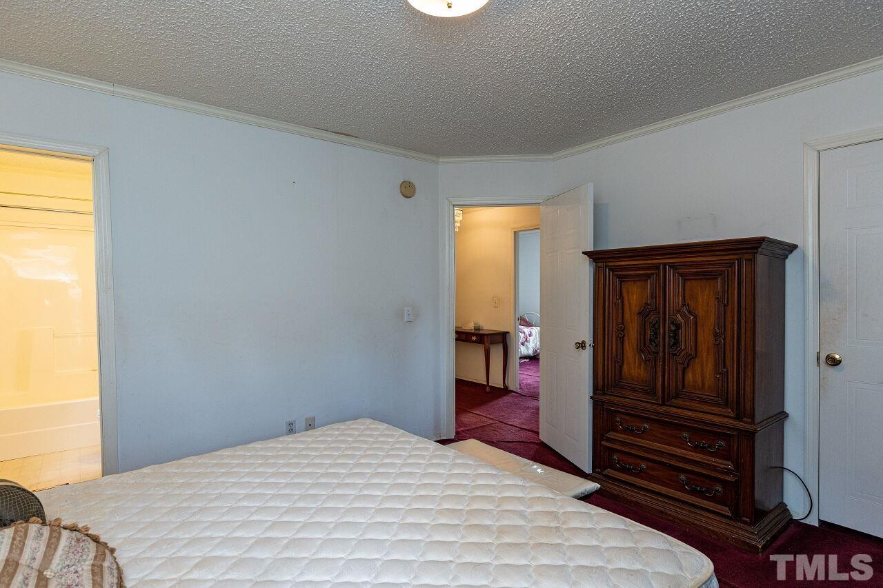 995 Genoa Road Dudley, NC 28333 - Photo 17 of 28 a bedroom with a bed and wooden floor