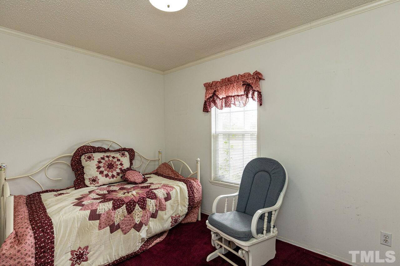 995 Genoa Road Dudley, NC 28333 - Photo 23 of 28 a bedroom with a bed and a chair