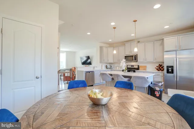 a kitchen with kitchen island a counter top space a sink stainless steel appliances and cabinets