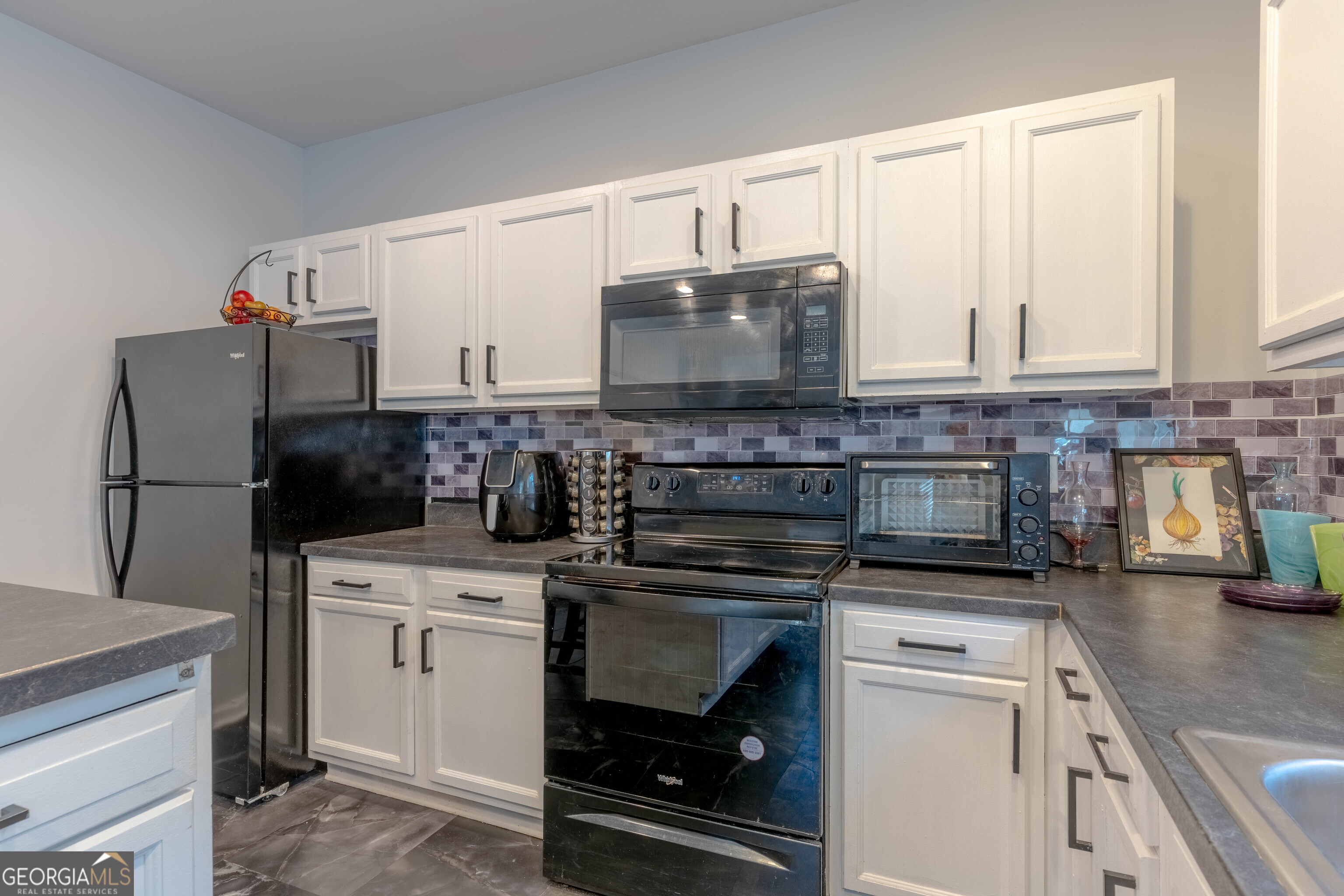 157 Watkins Road Flovilla, GA 30216 - Photo 11 of 31 a kitchen with stainless steel appliances a stove a sink and a refrigerator