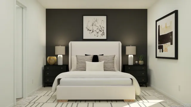 a bedroom with a large bed and a lamp on dresser