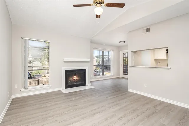 a view of an empty room with a fireplace and a window