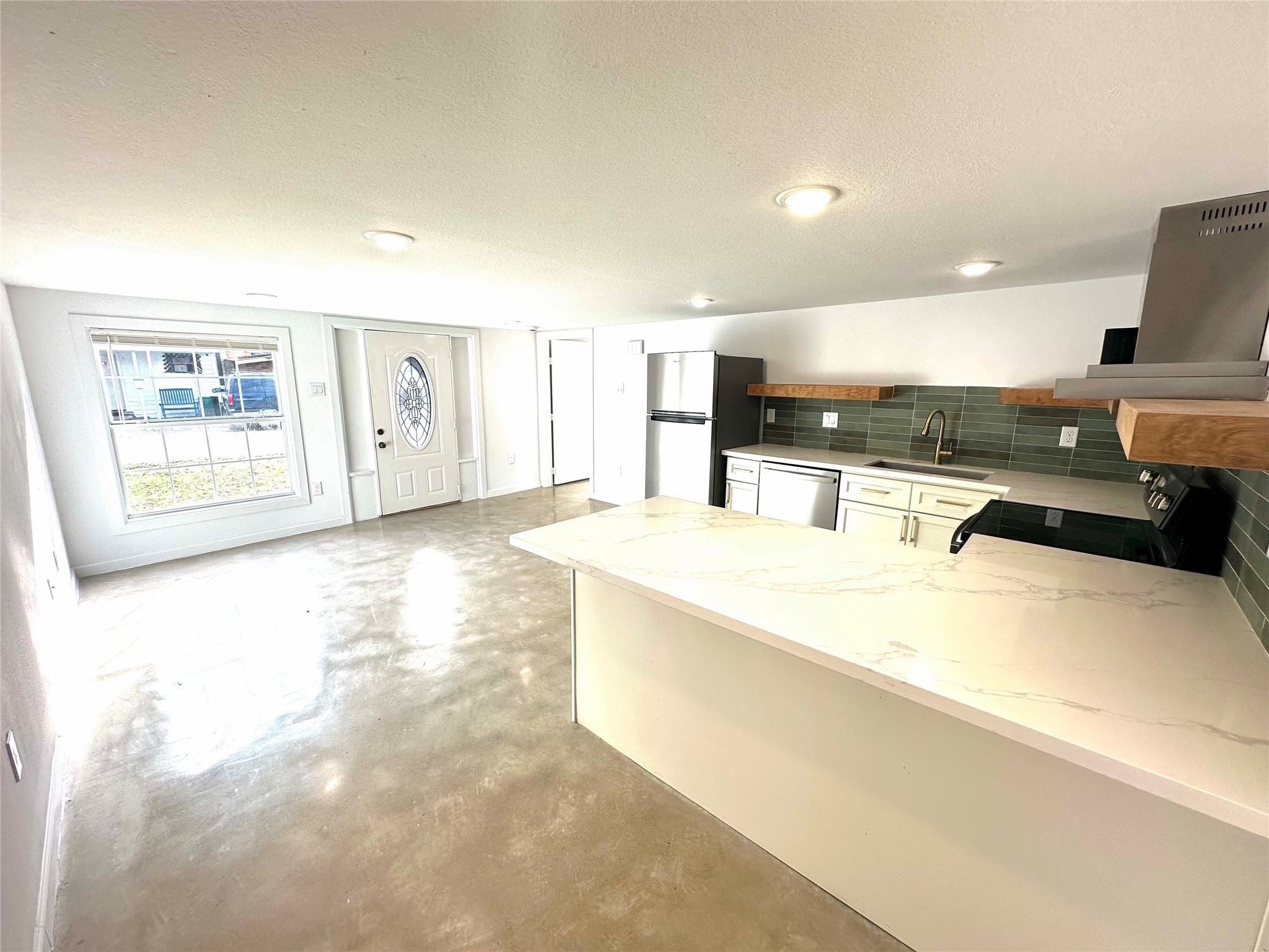 808 Oakhurst Street, Unit 3 Houston, TX 77023 - Photo 5 of 10 a large kitchen with stainless steel appliances kitchen island a large counter top and a stove top oven