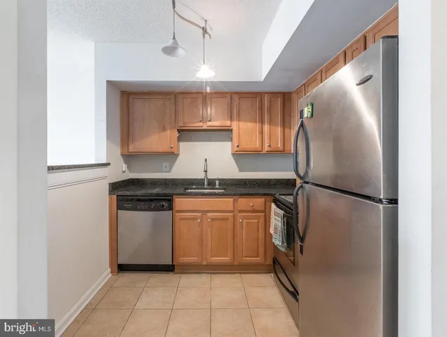 a kitchen with stainless steel appliances granite countertop a refrigerator and a stove