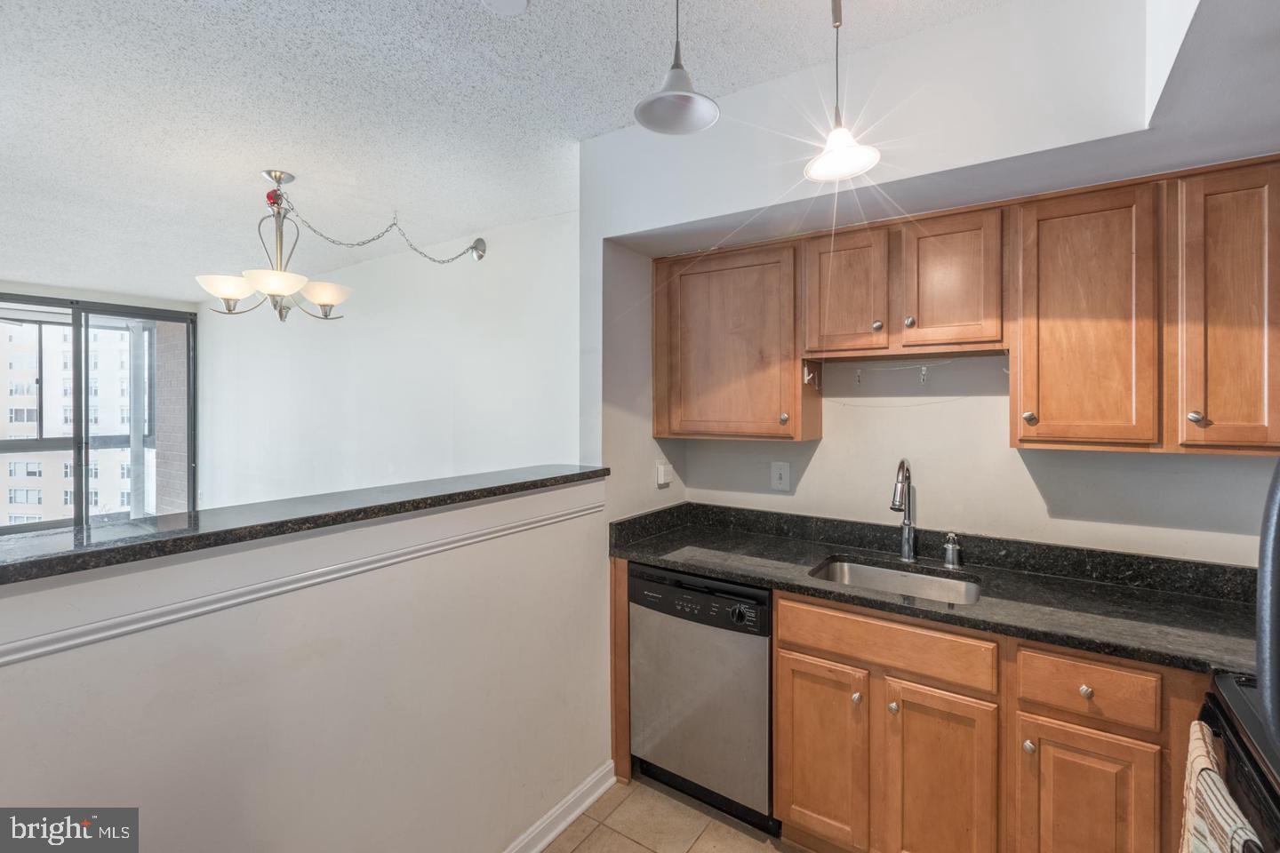 1001 North Randolph Street, Unit 811 Arlington, VA 22201 - Photo 3 of 30 a kitchen with granite countertop a sink a stove and cabinets