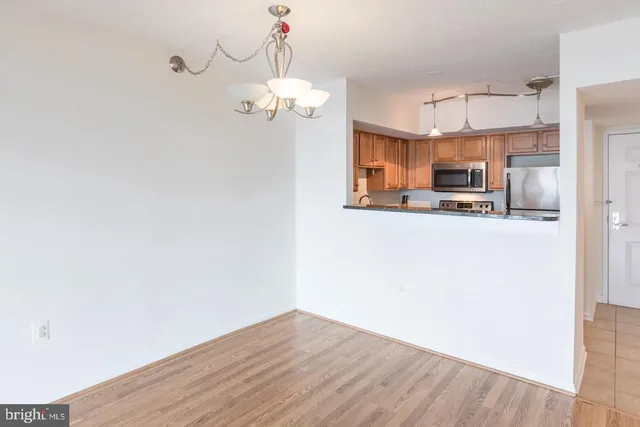 a view of a kitchen with a sink wooden floor and a refrigerator