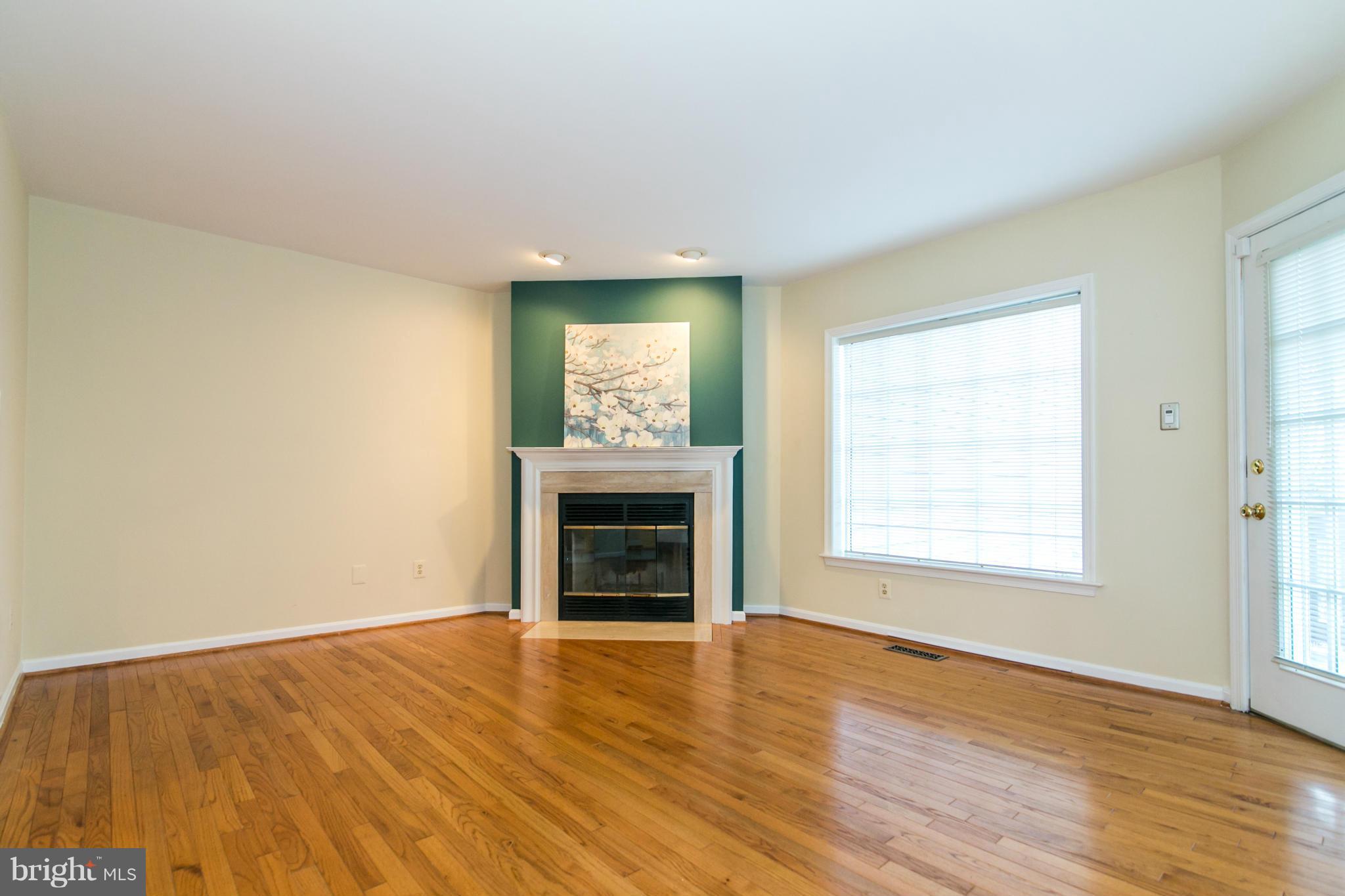 1510 Deer Point Way Reston, VA 20194 - Photo 3 of 30 an empty room with wooden floor fireplace and windows