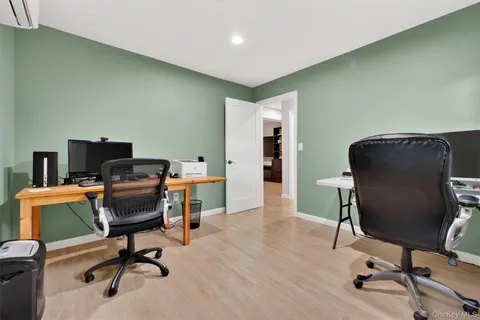 a view of a workspace with furniture and a window