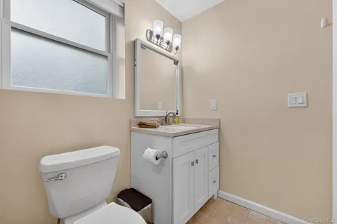a bathroom with a sink a toilet and a mirror